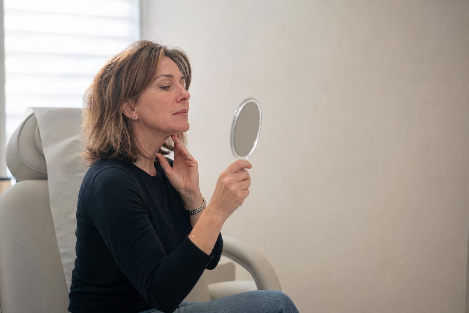 A woman in her thirties reading about Ultherapy on her phone before a consultation at a Gangnam clinic